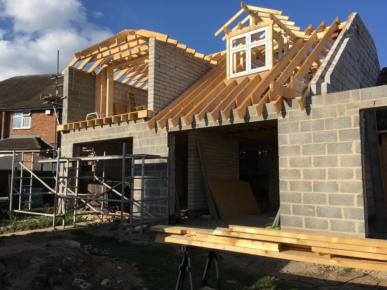Loft conversion under construction with new rafters, dormer framing and blockwork.