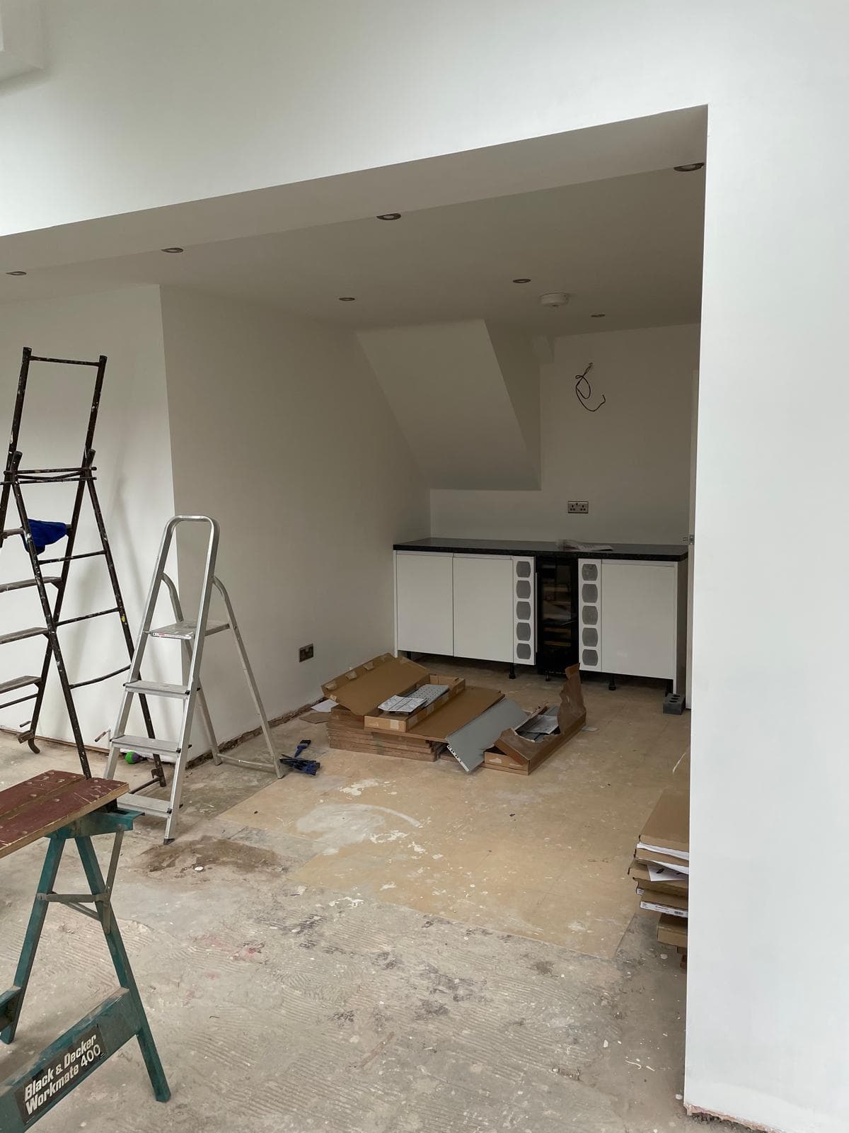 Bright interior with fresh plaster and kitchen units being installed.