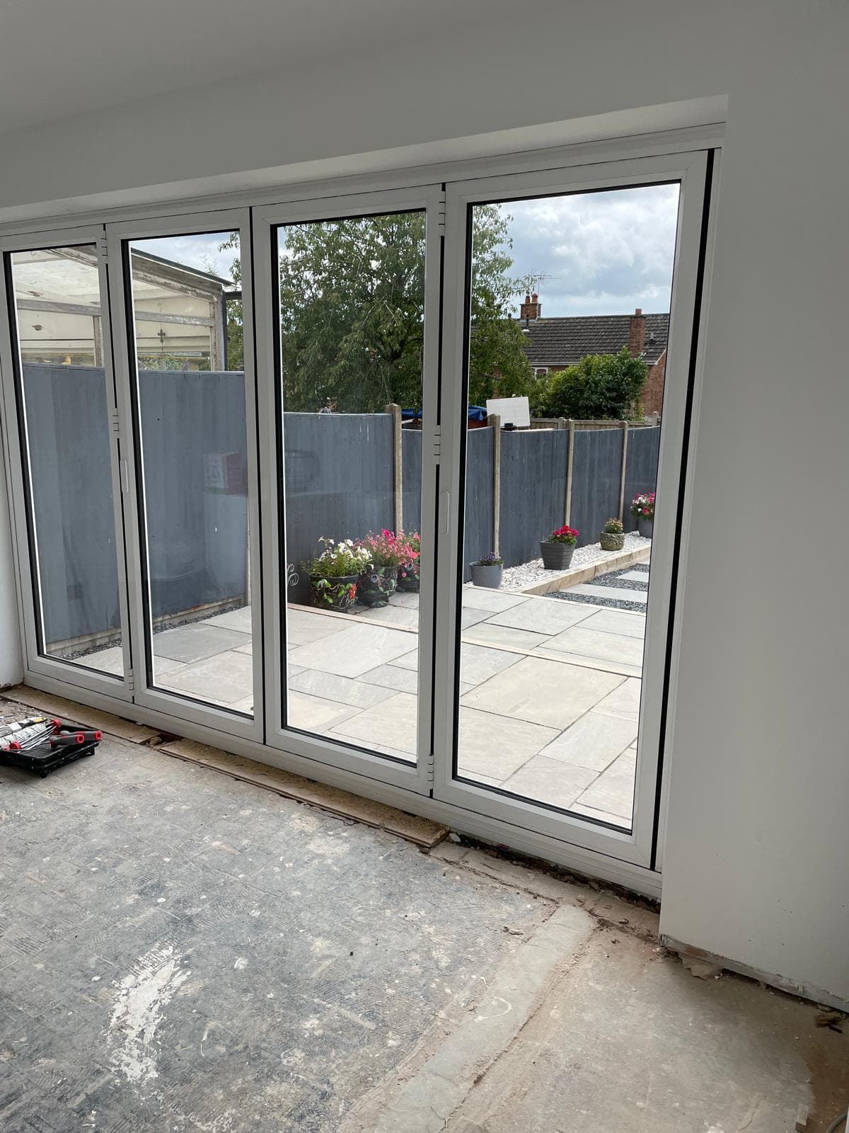 New bifold doors opening onto a paved patio.