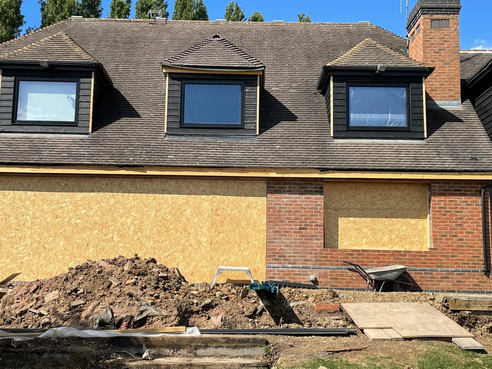 Rear of a property with new openings formed and boarded ready for glazing.