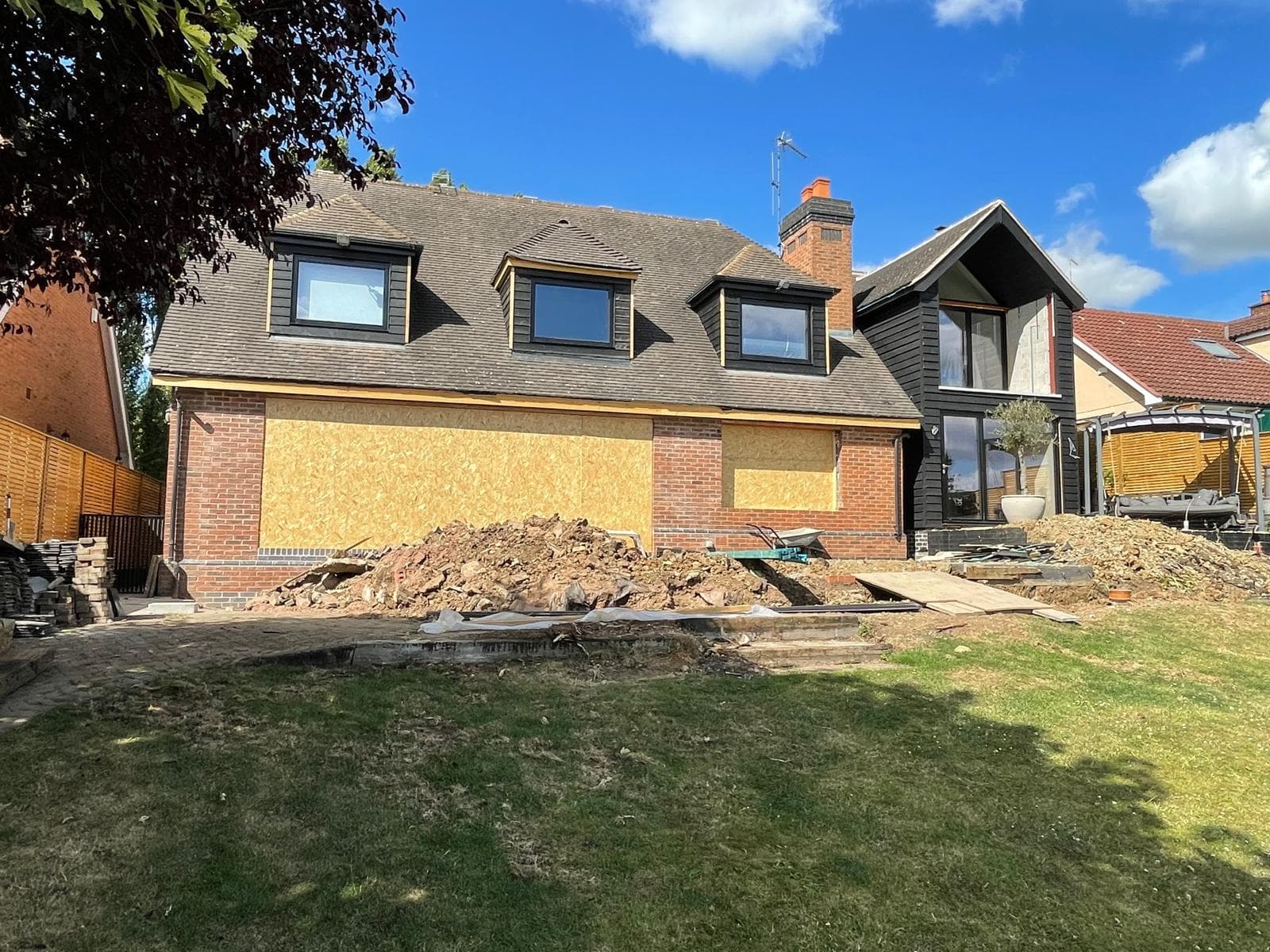 Rear elevation mid-works, seen across the garden.