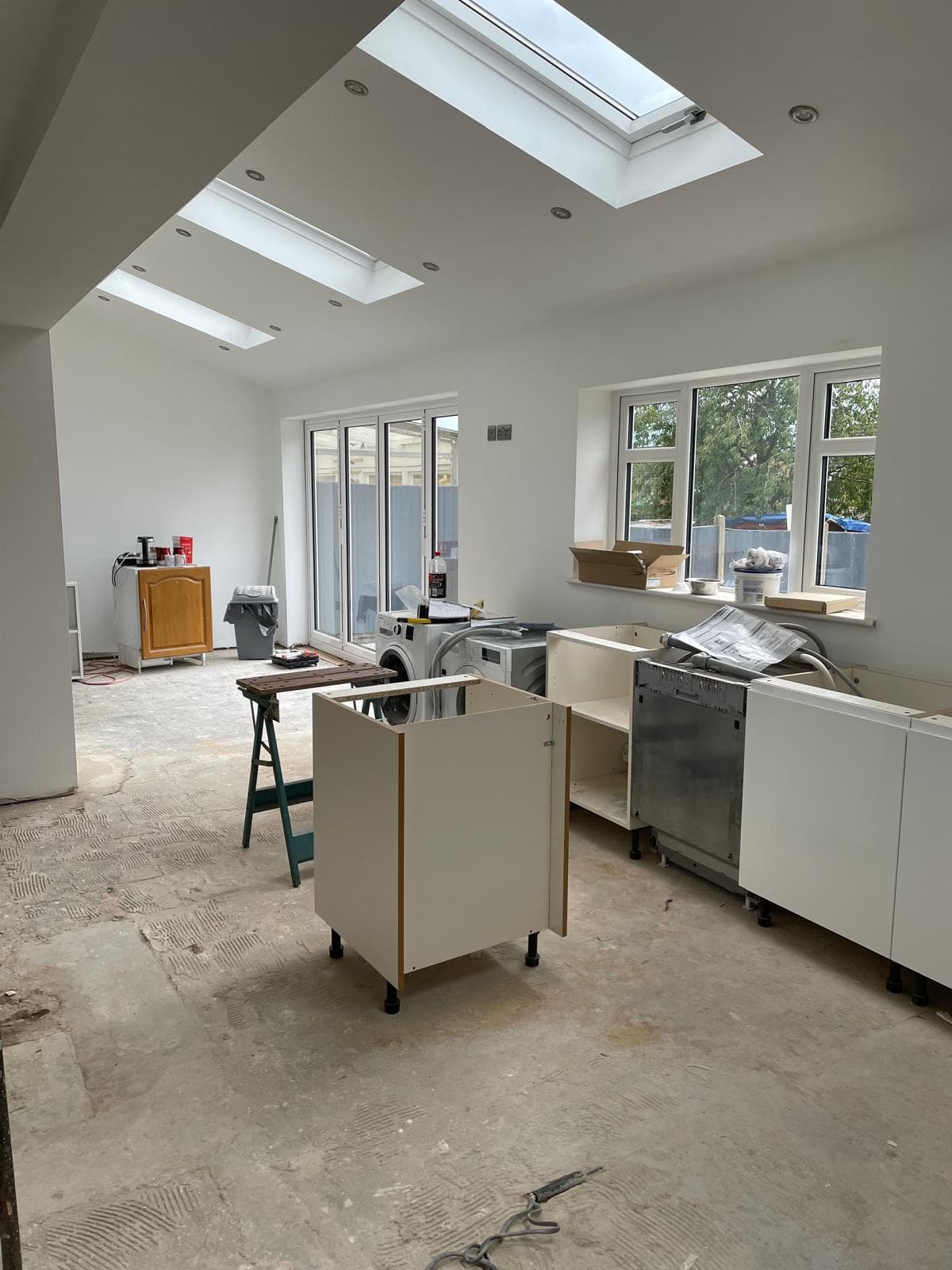 Kitchen installation underway in a new extension with rooflights and bifold doors.
