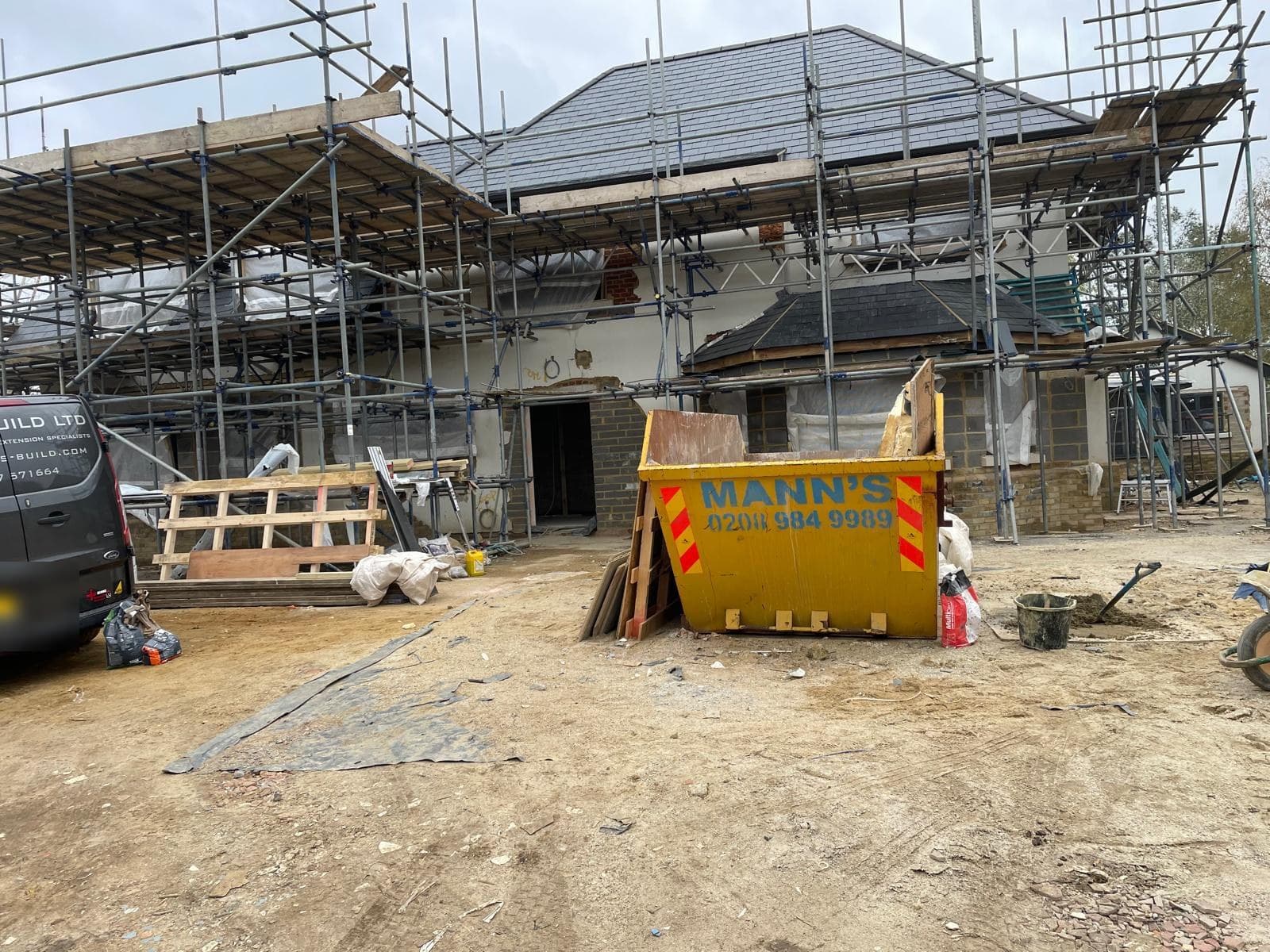 Whole-house renovation under full scaffolding with site set up for works.