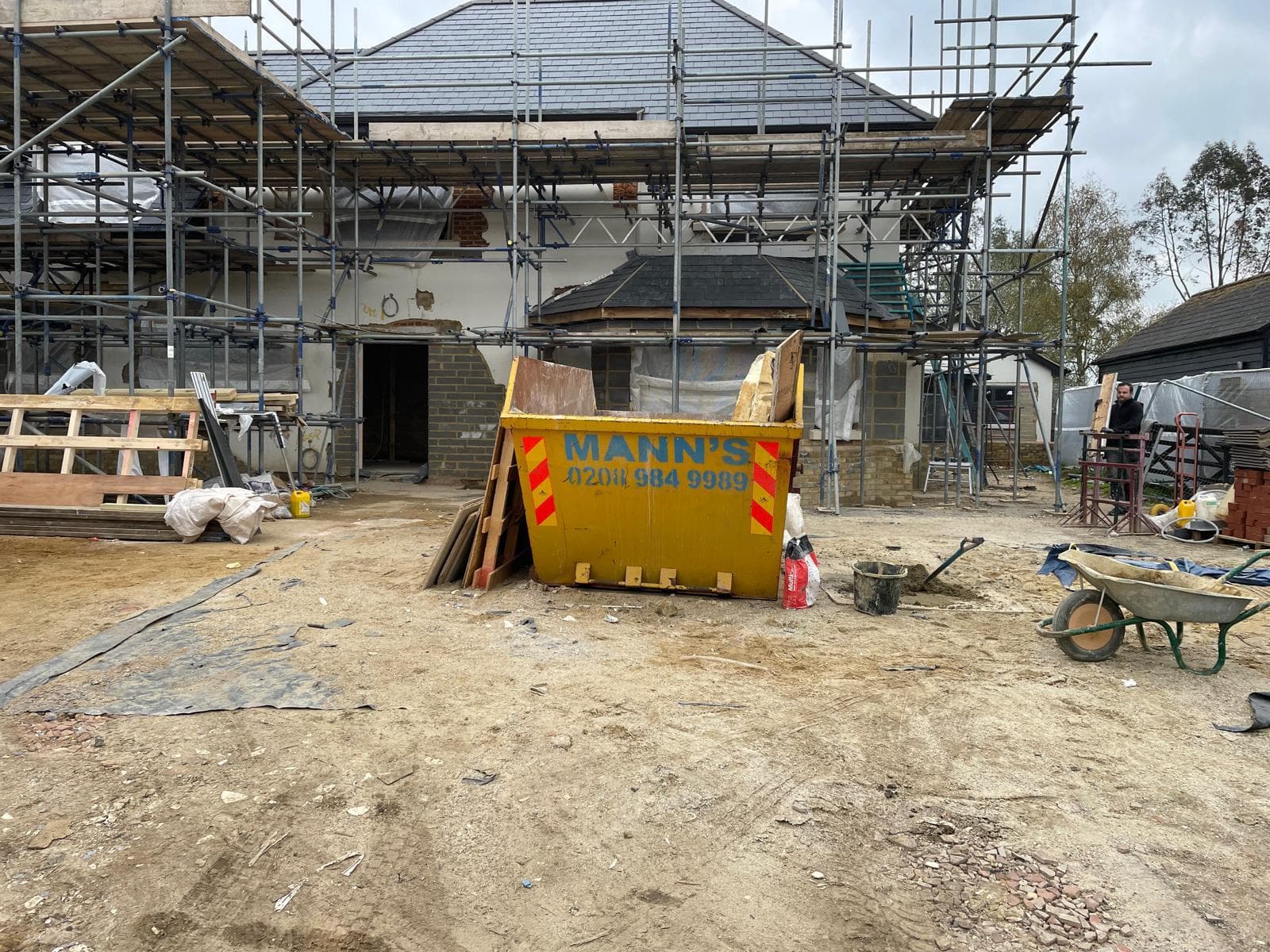 Detached house mid-renovation under full scaffolding.