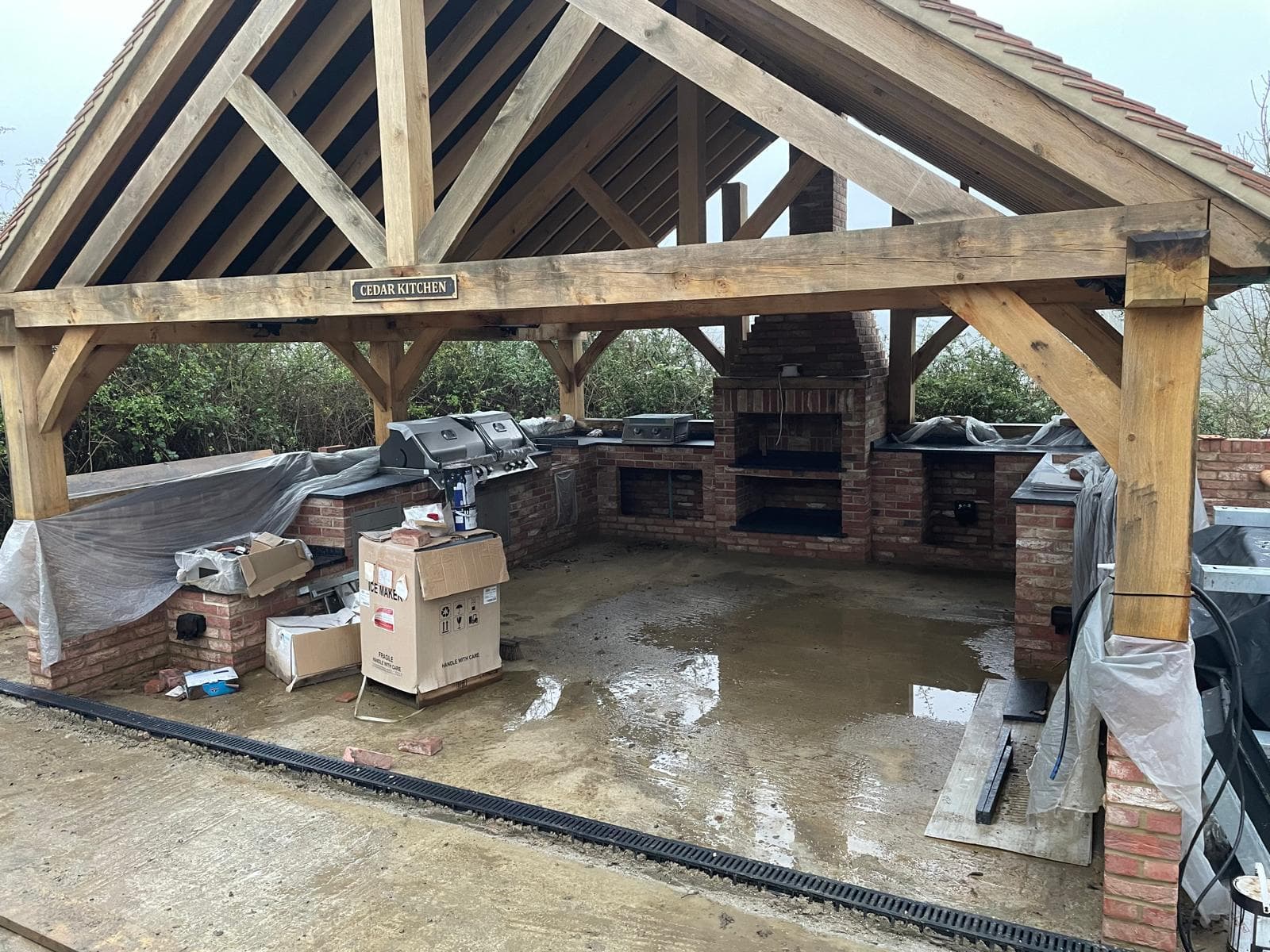 Interior of an oak-framed garden building with brick-built kitchen counters.