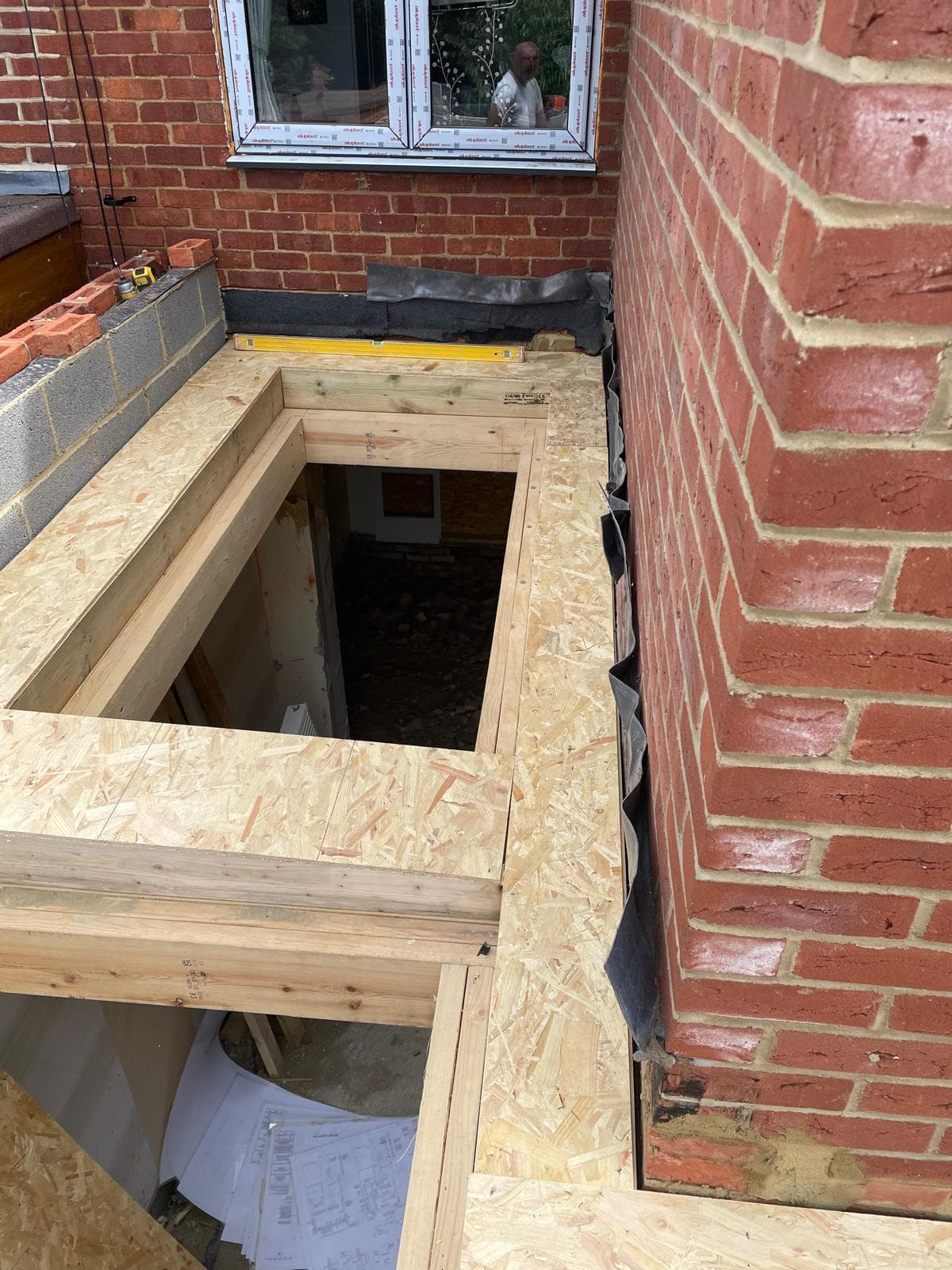 New floor deck framed against an existing brick wall.