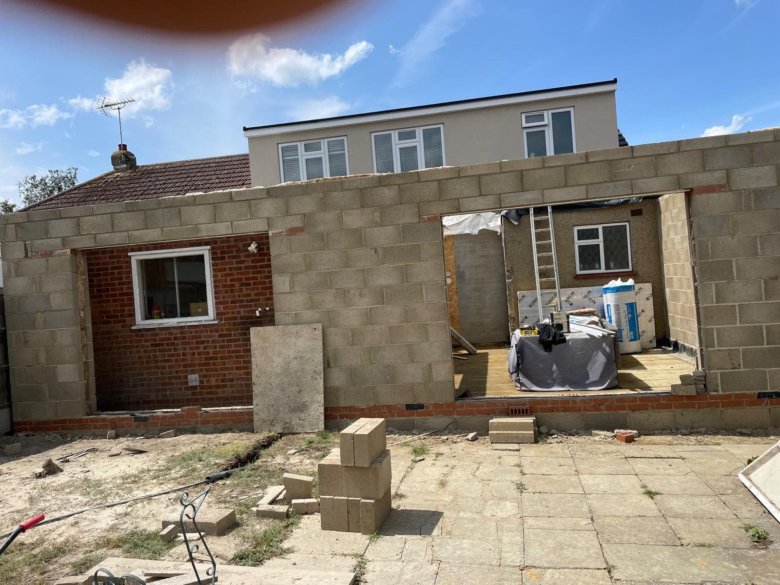 Blockwork shell of a wraparound extension to a bungalow.