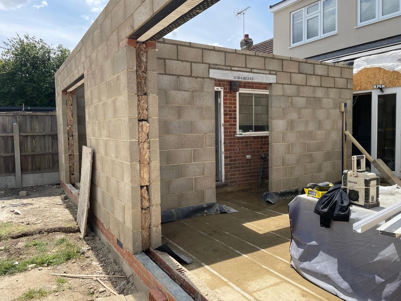 Corner of a new blockwork extension with door opening formed.