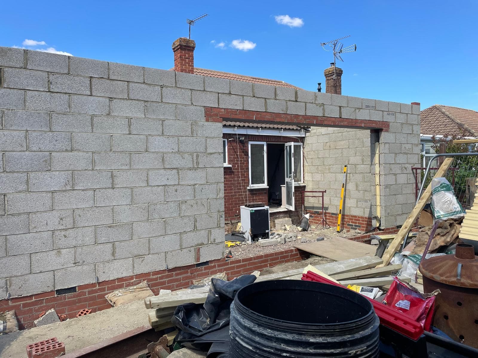 Blockwork extension with drainage and groundworks in progress.